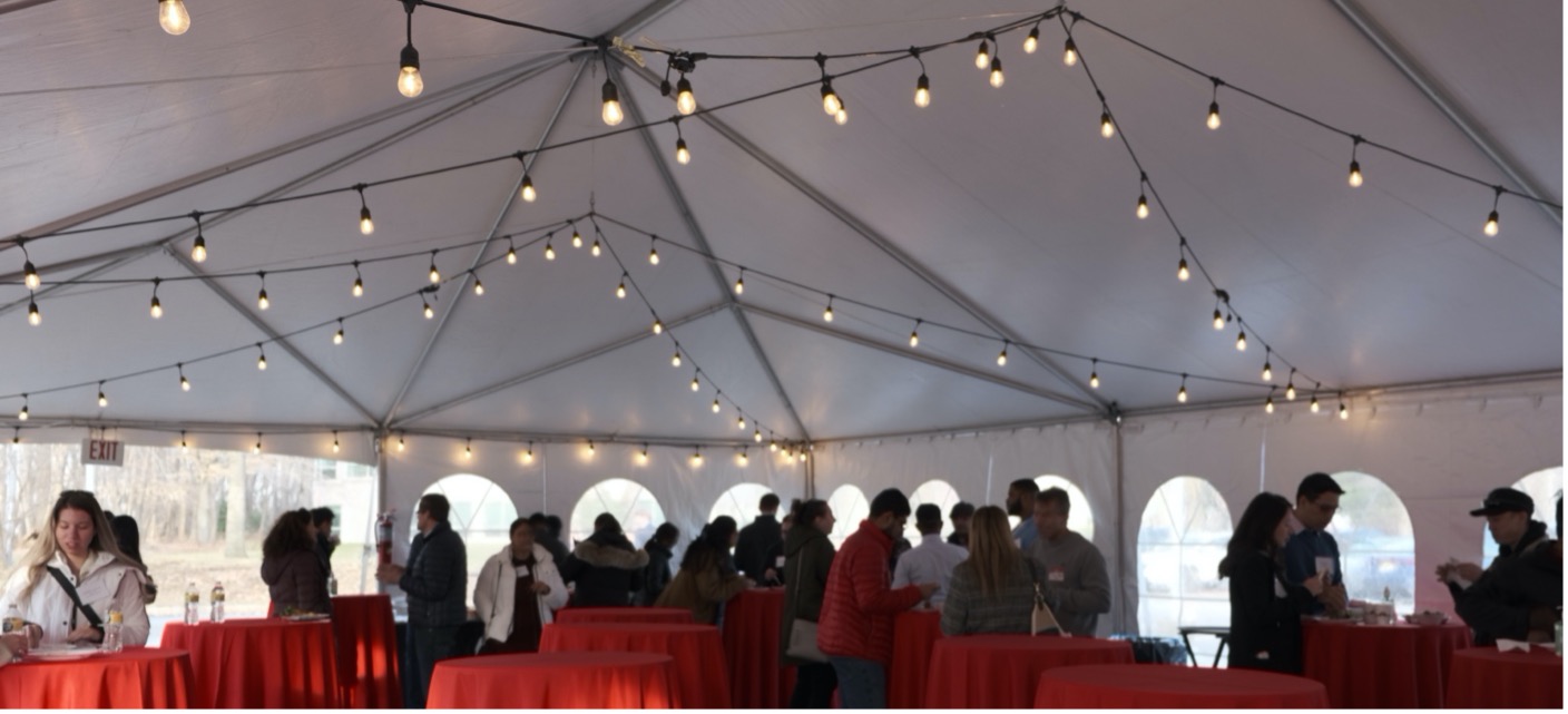 MBS faculty, staff, students, and alumni gathered under a canopy
