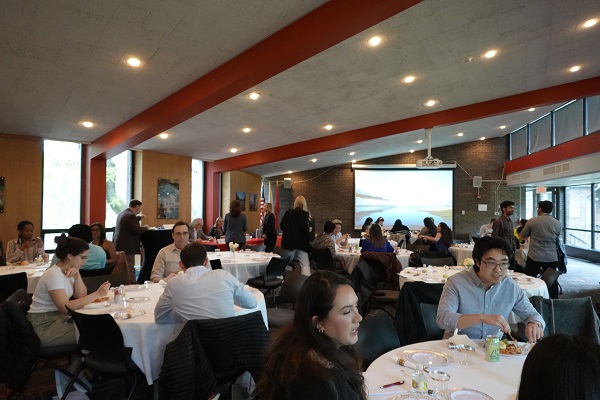Students seated at tables networking and enjoying dinner