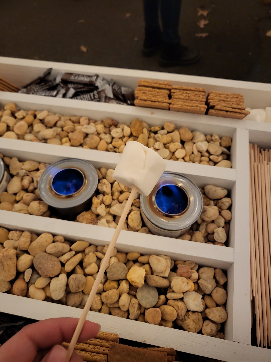 table display of marshmallows, chocolate, graham crackers, and sterno candles to make s'mores
