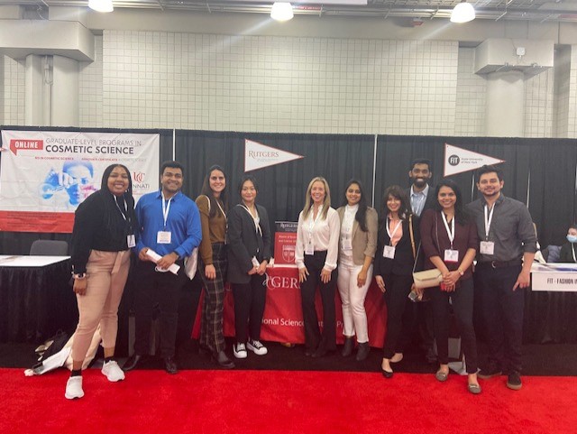 Students, alumni, and faculty standing around Rutgers PSM booth