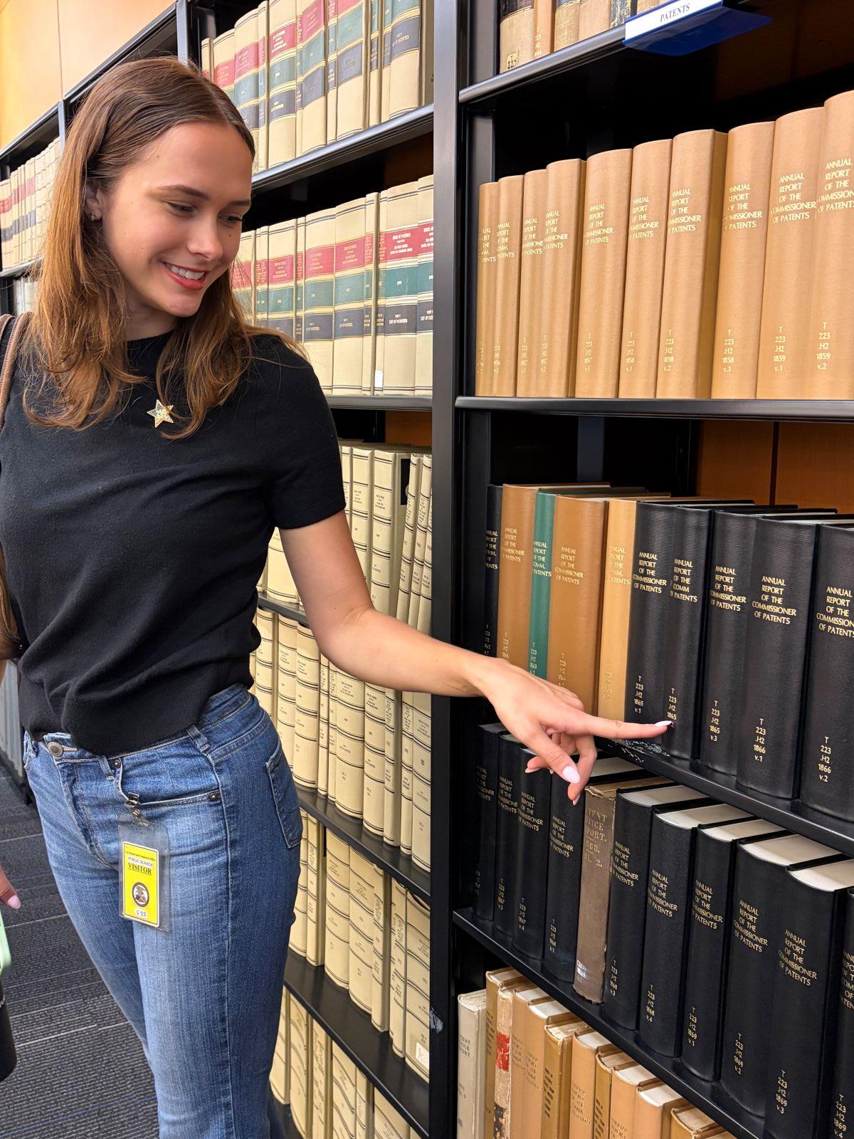 Woman touching book on shelf