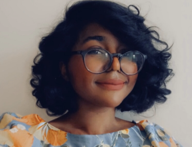 Professional headshot of woman wearing floral top and glasses