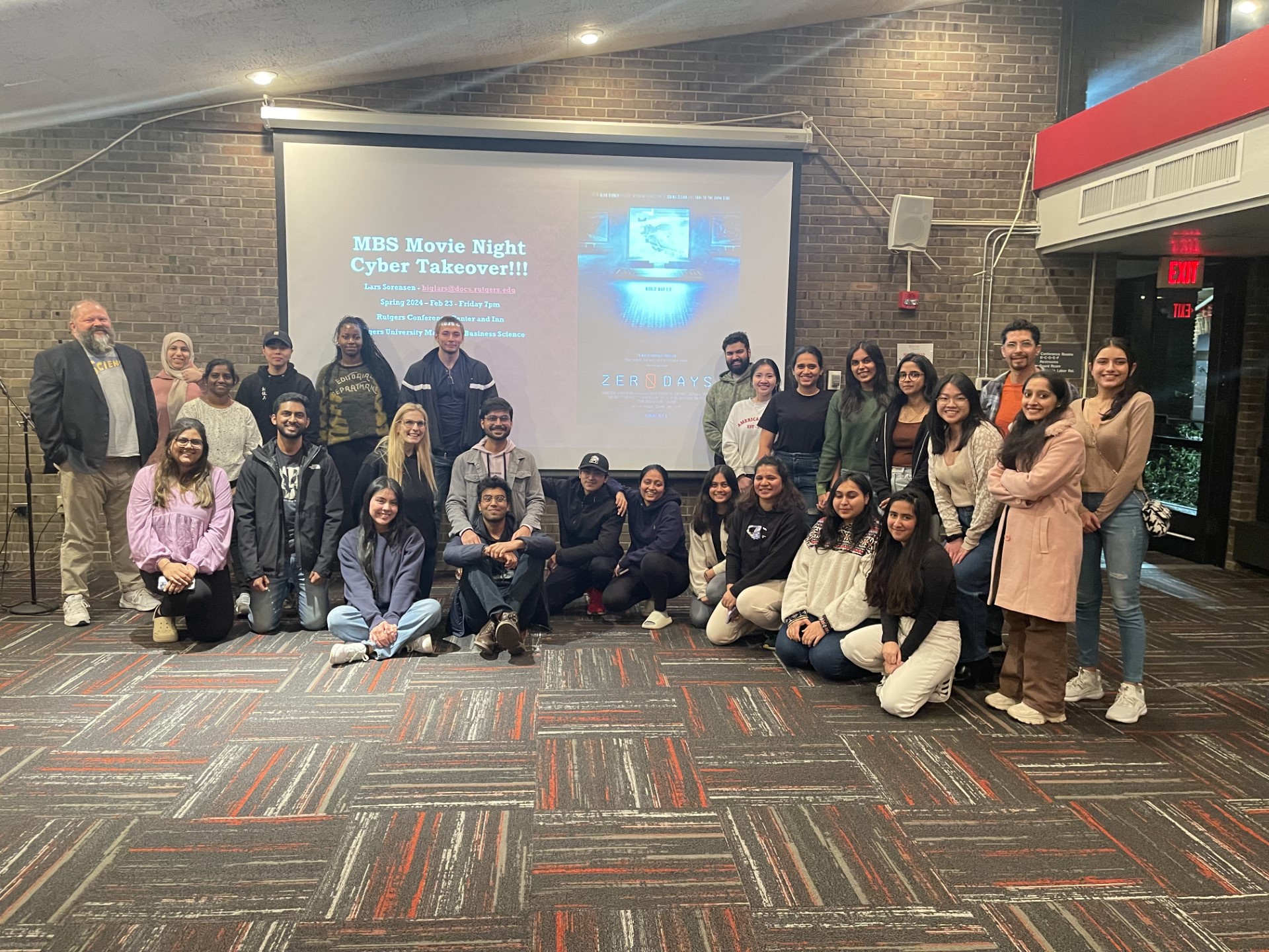 students and faculty gathered around a projection screen
