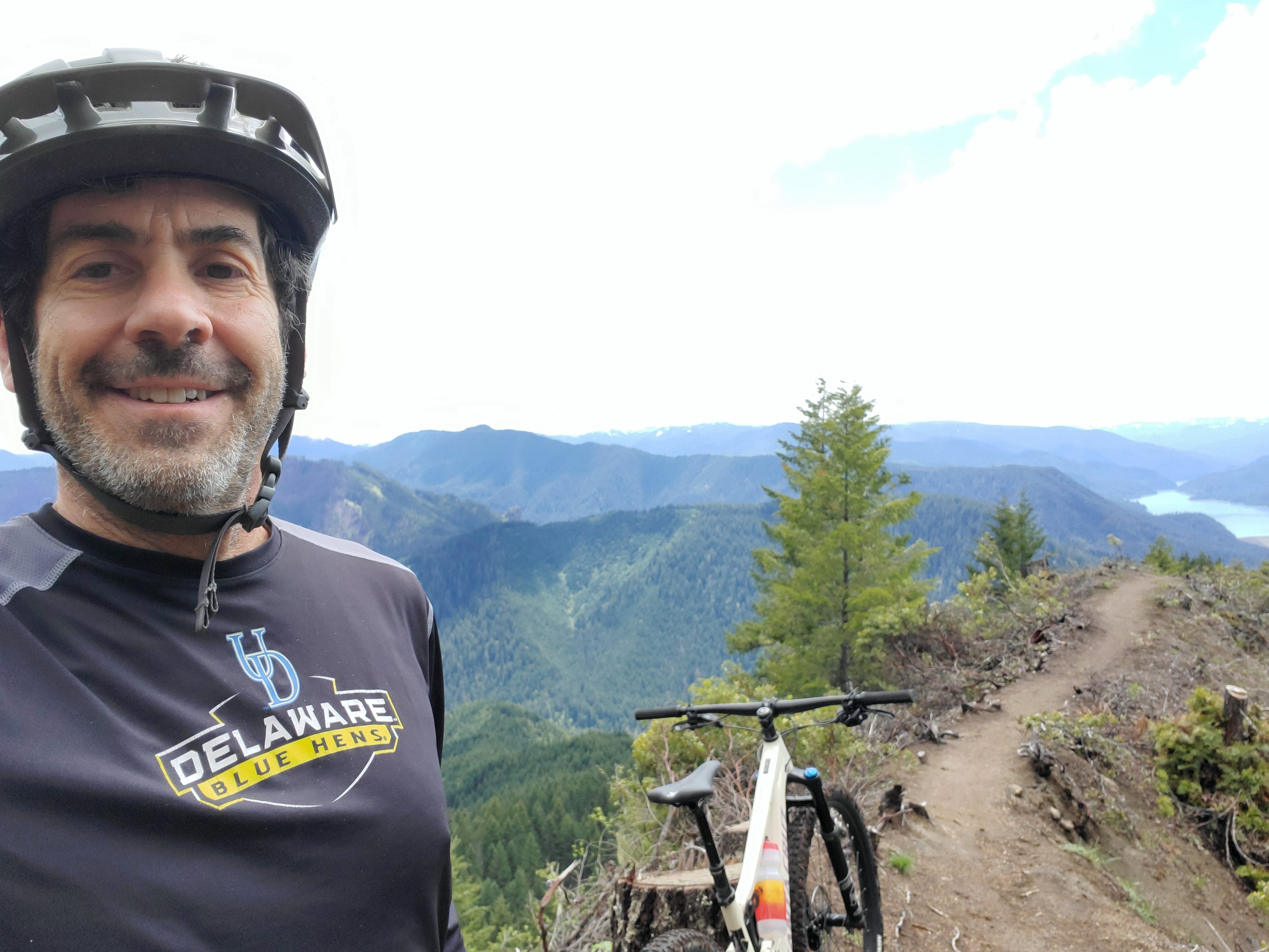 Man standing with bicycle on a dirt road