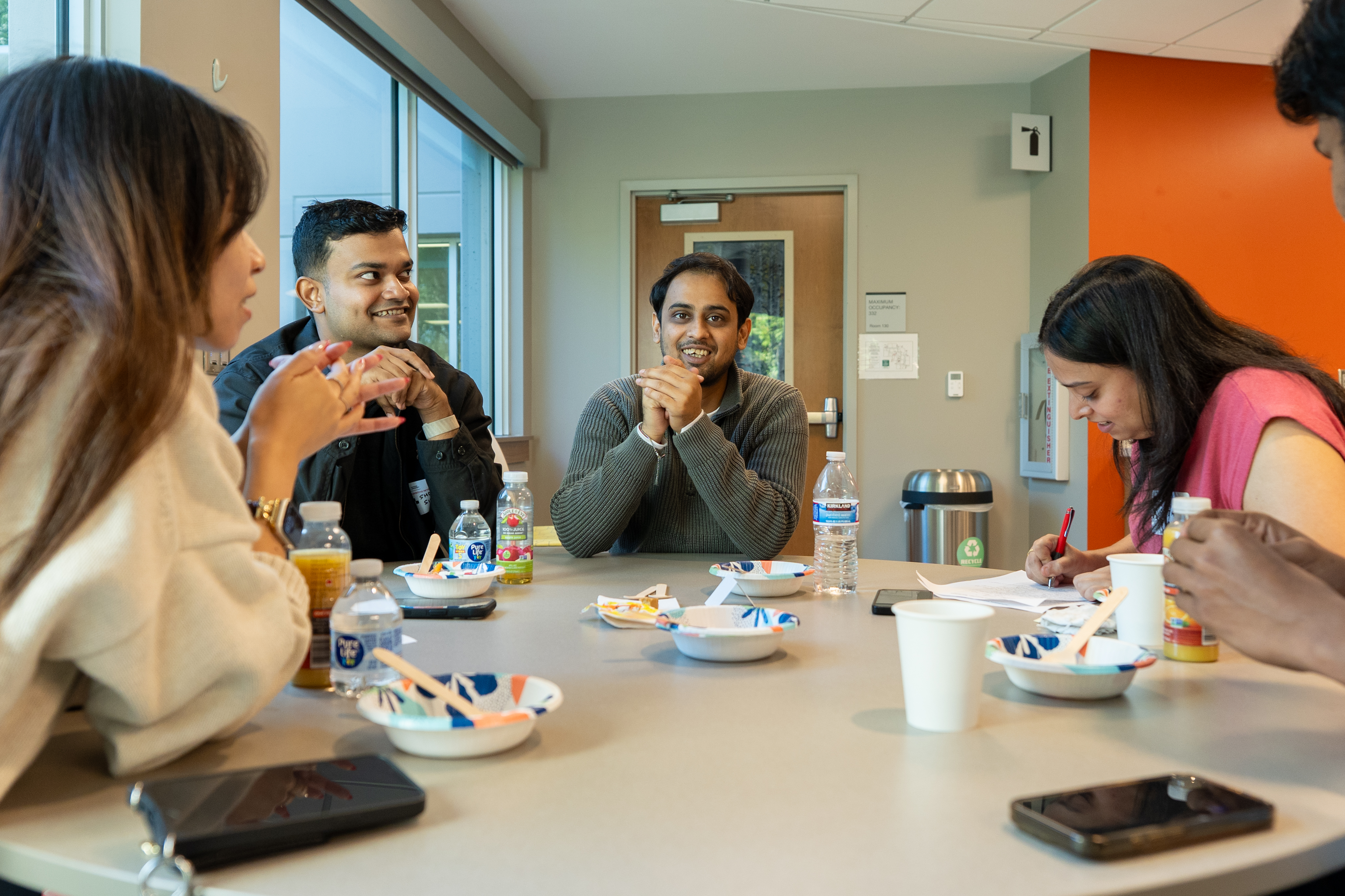 A group of students laughing and discussing 