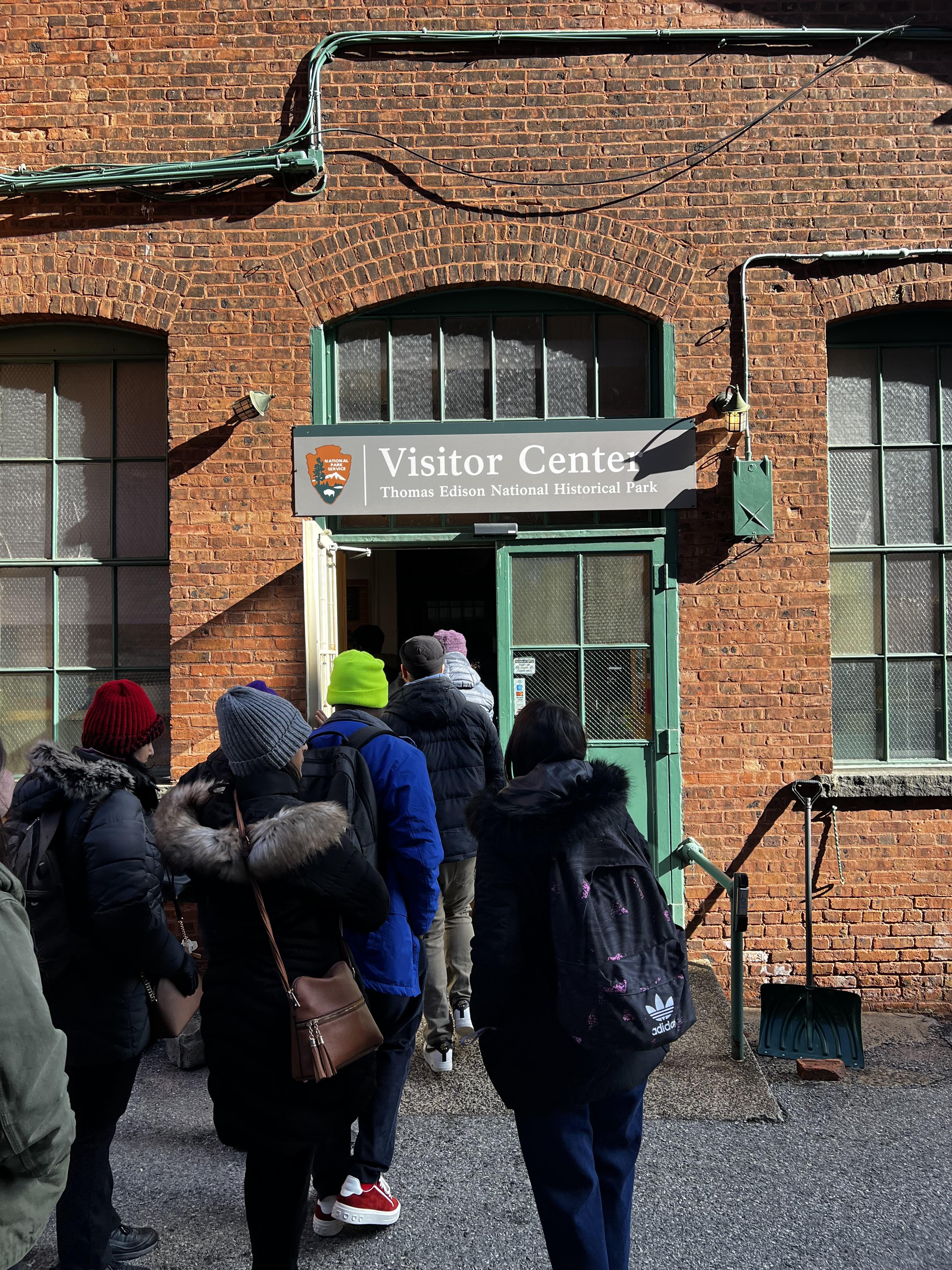 People entering a building with the sight "visitor center"