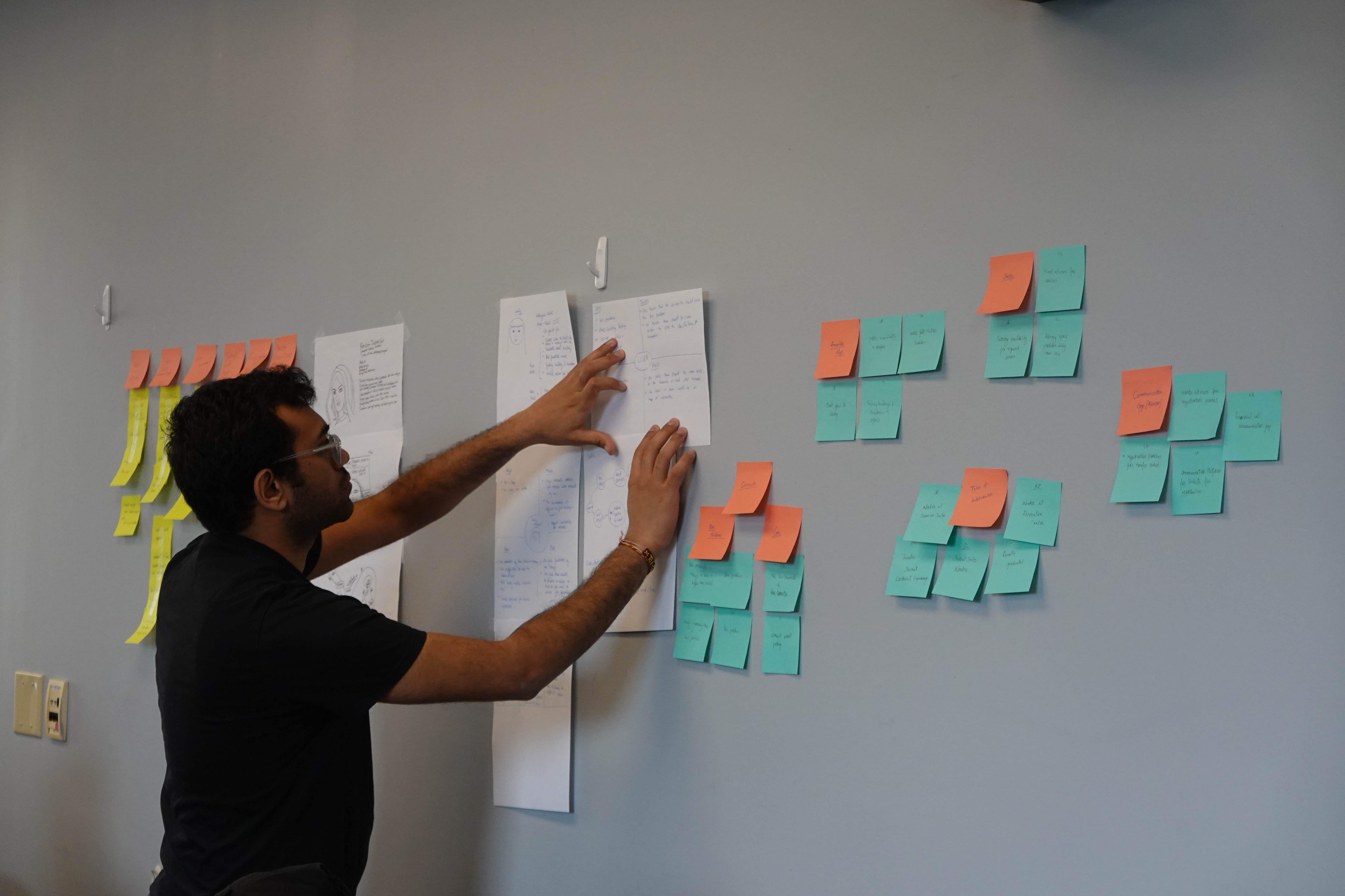 A student hanging notes on the wall