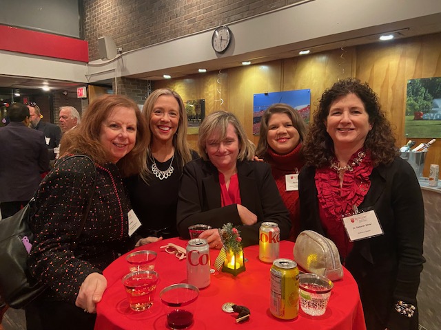 MBS faculty standing around a red table