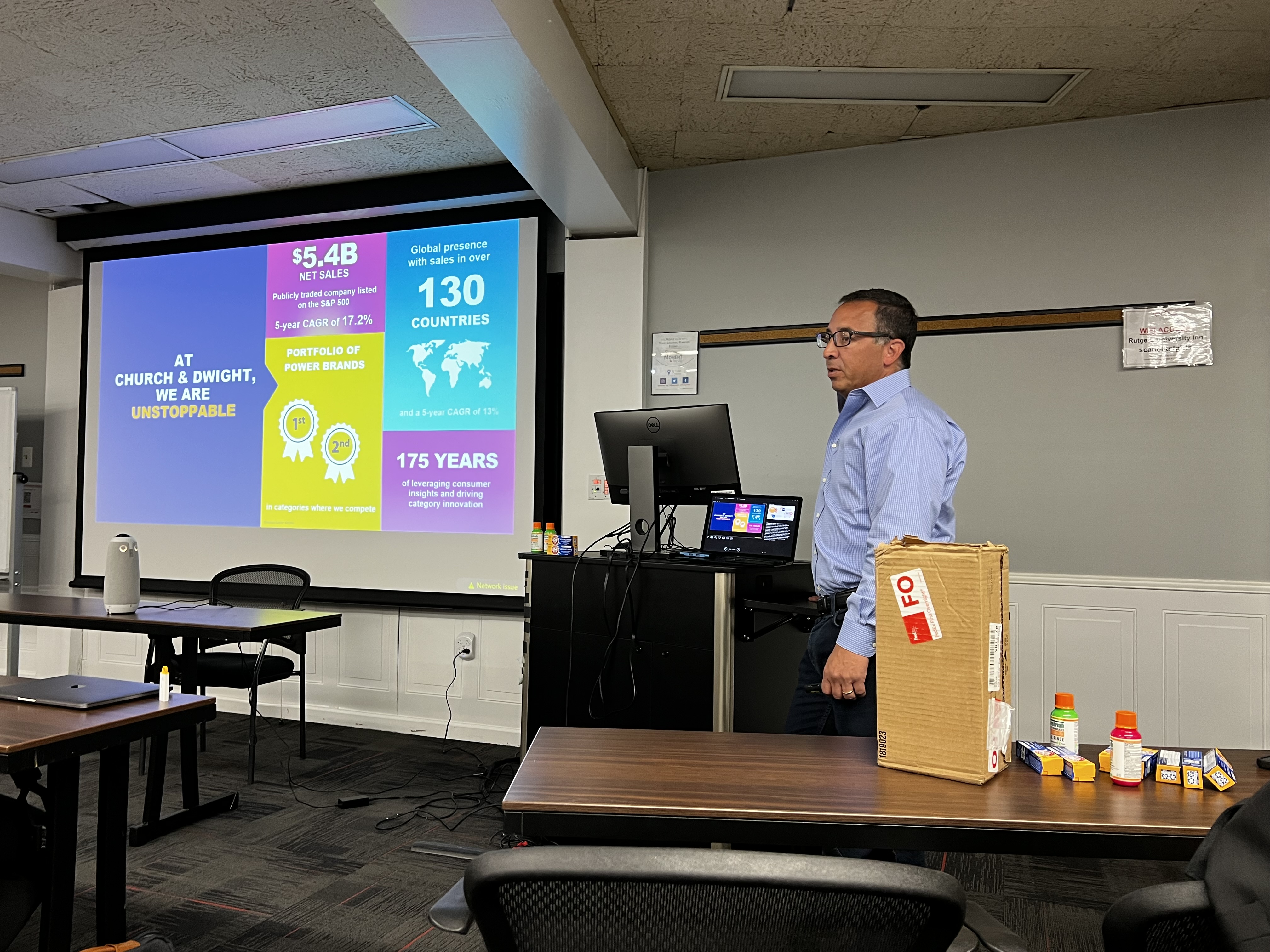 Speaker standing in front of presentation on screen.