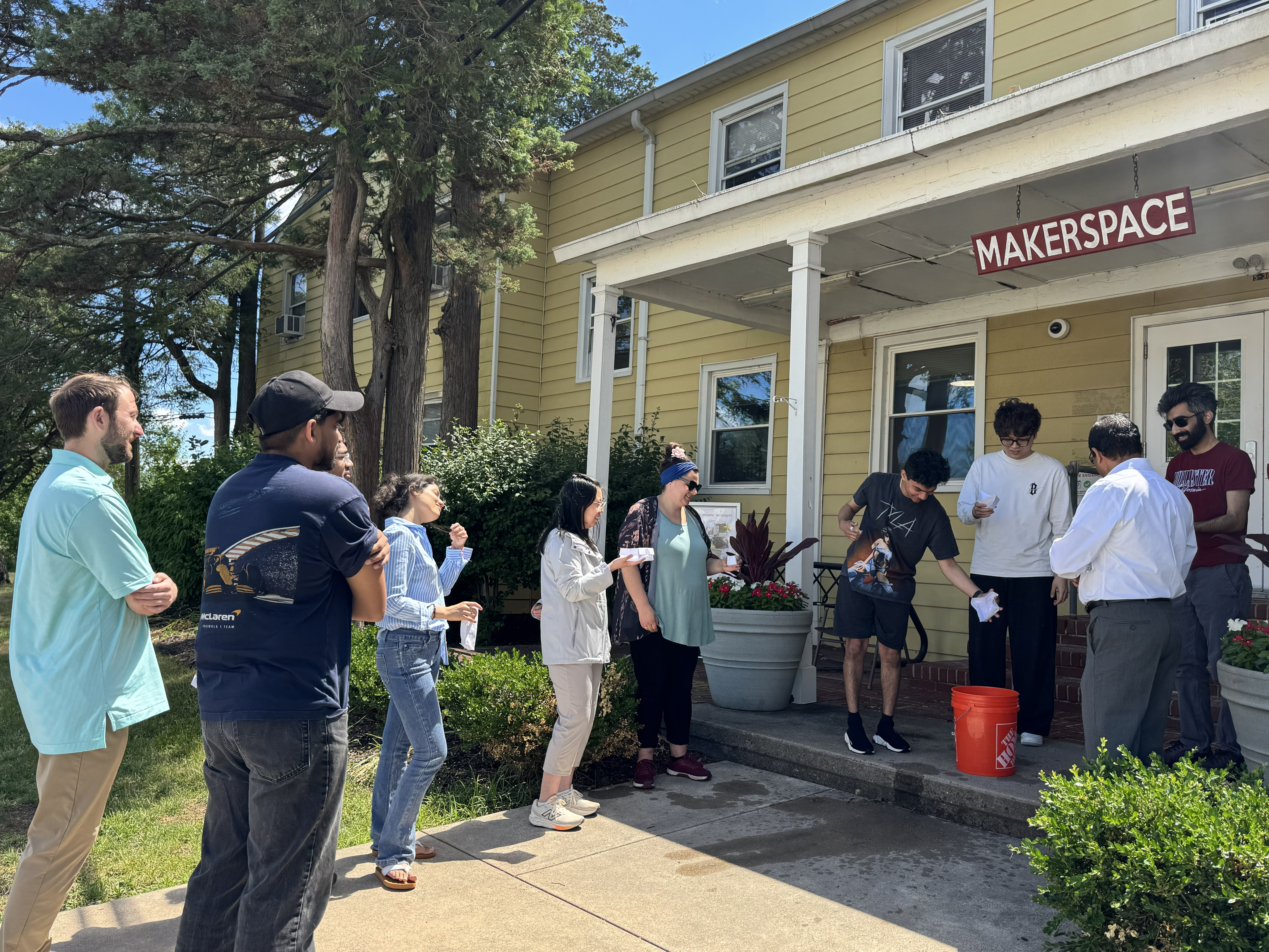 A photo of many people outside a house, enjoying the summer