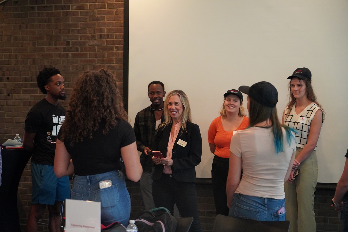 faculty member talking to students in a circle.