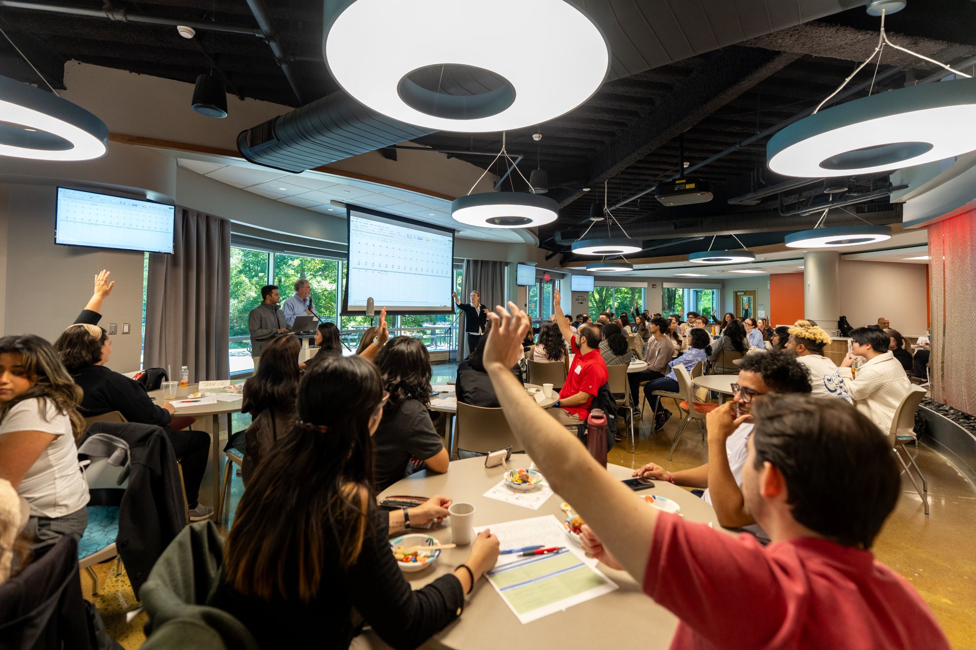 Students raising their hands to answer a question during an event