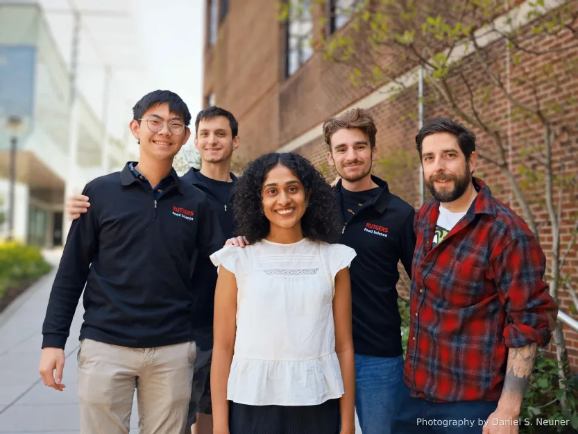 A team of 4 students with their professor