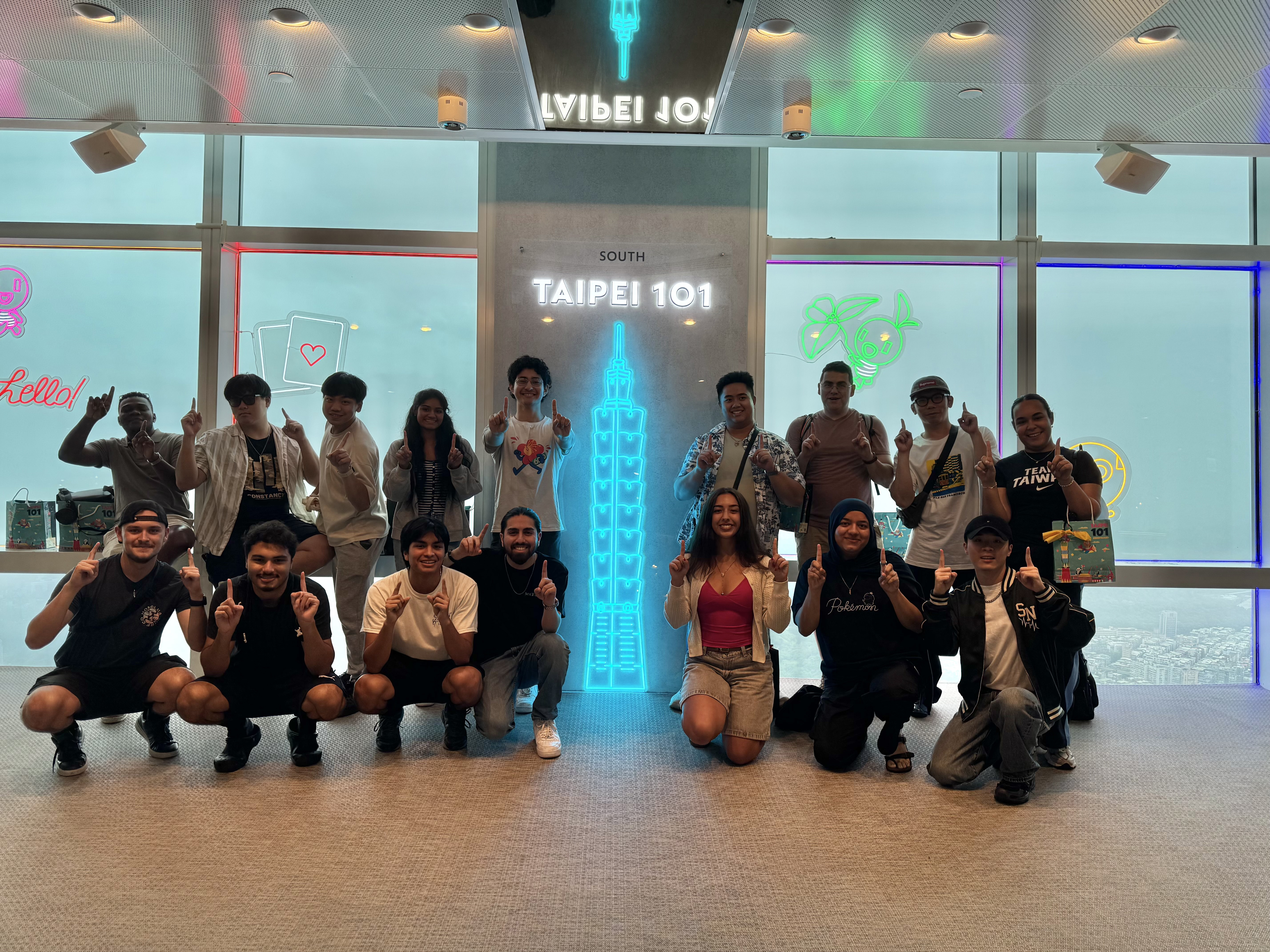 students next to a sign that reads Taipei 101