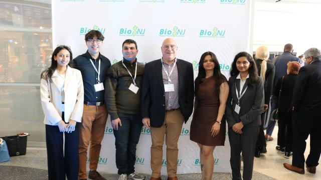 A group of students with their professor at a conference
