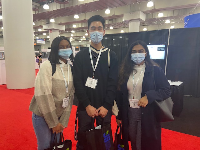 two female students on either side of a tall male student