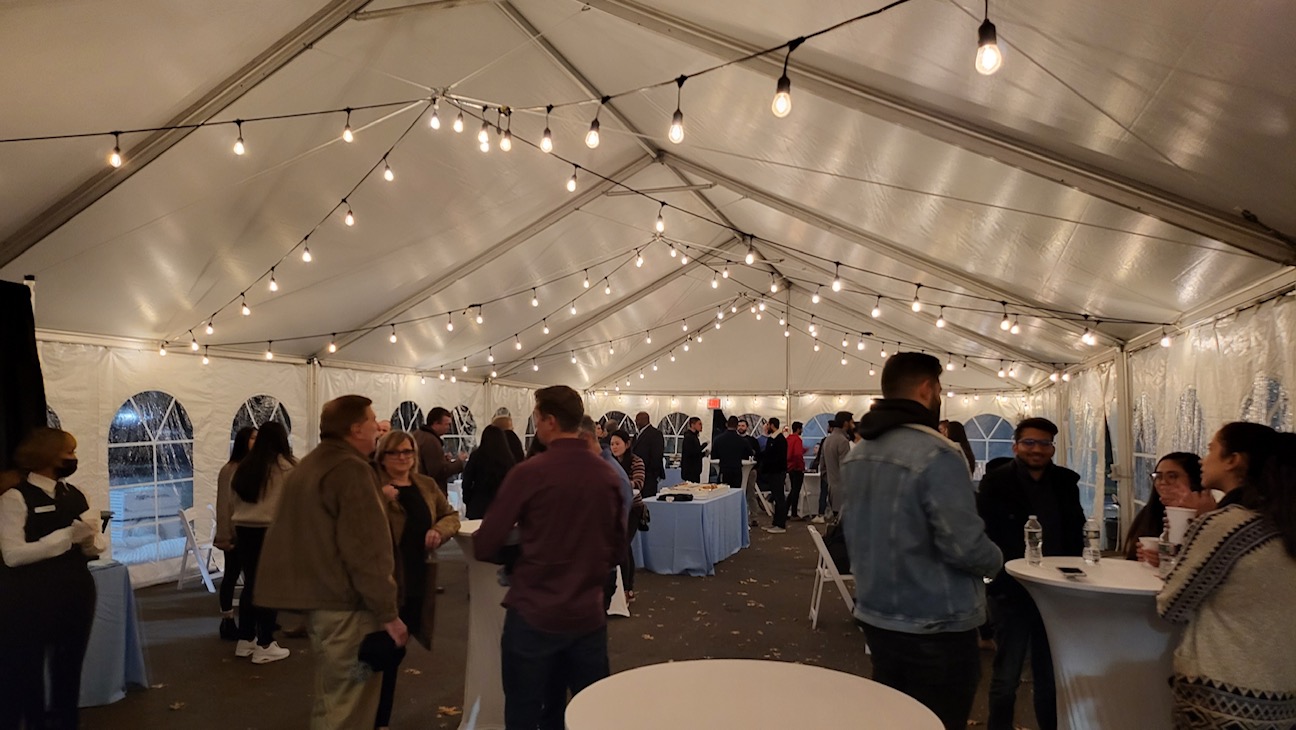 young adults mingling in a heated, lighted tent