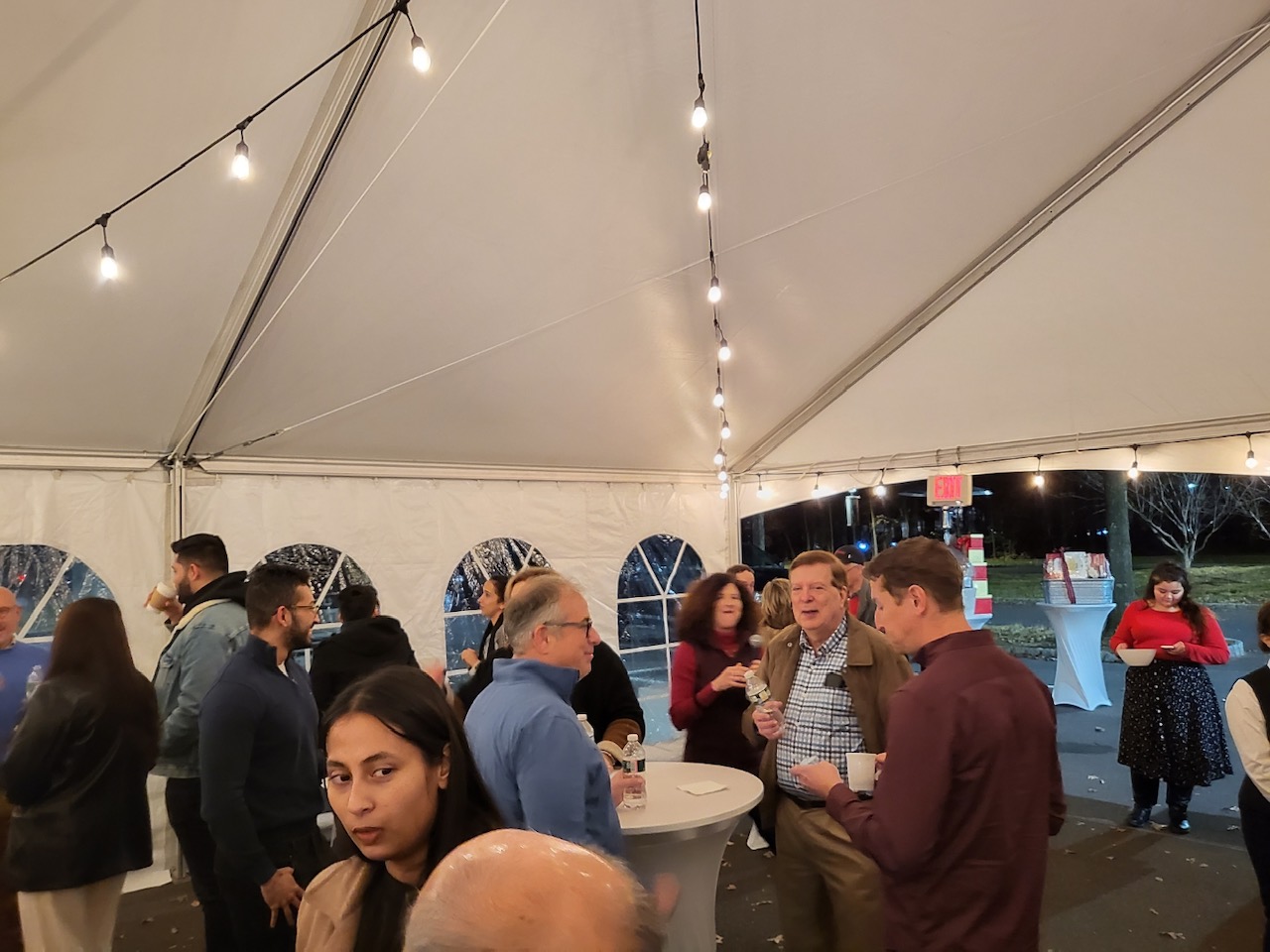 adults mingling in a heated, lighted tent