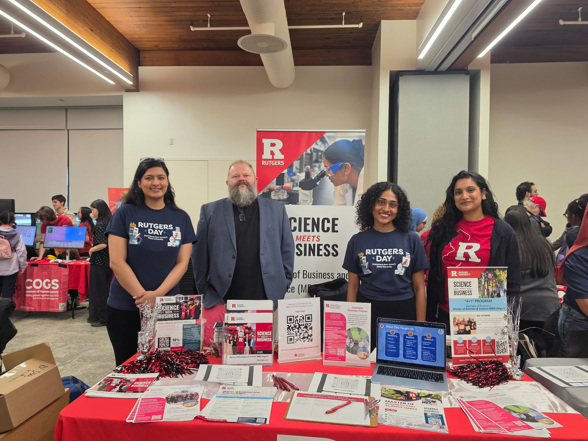 students and professor hosting a booth at Rutgers Day