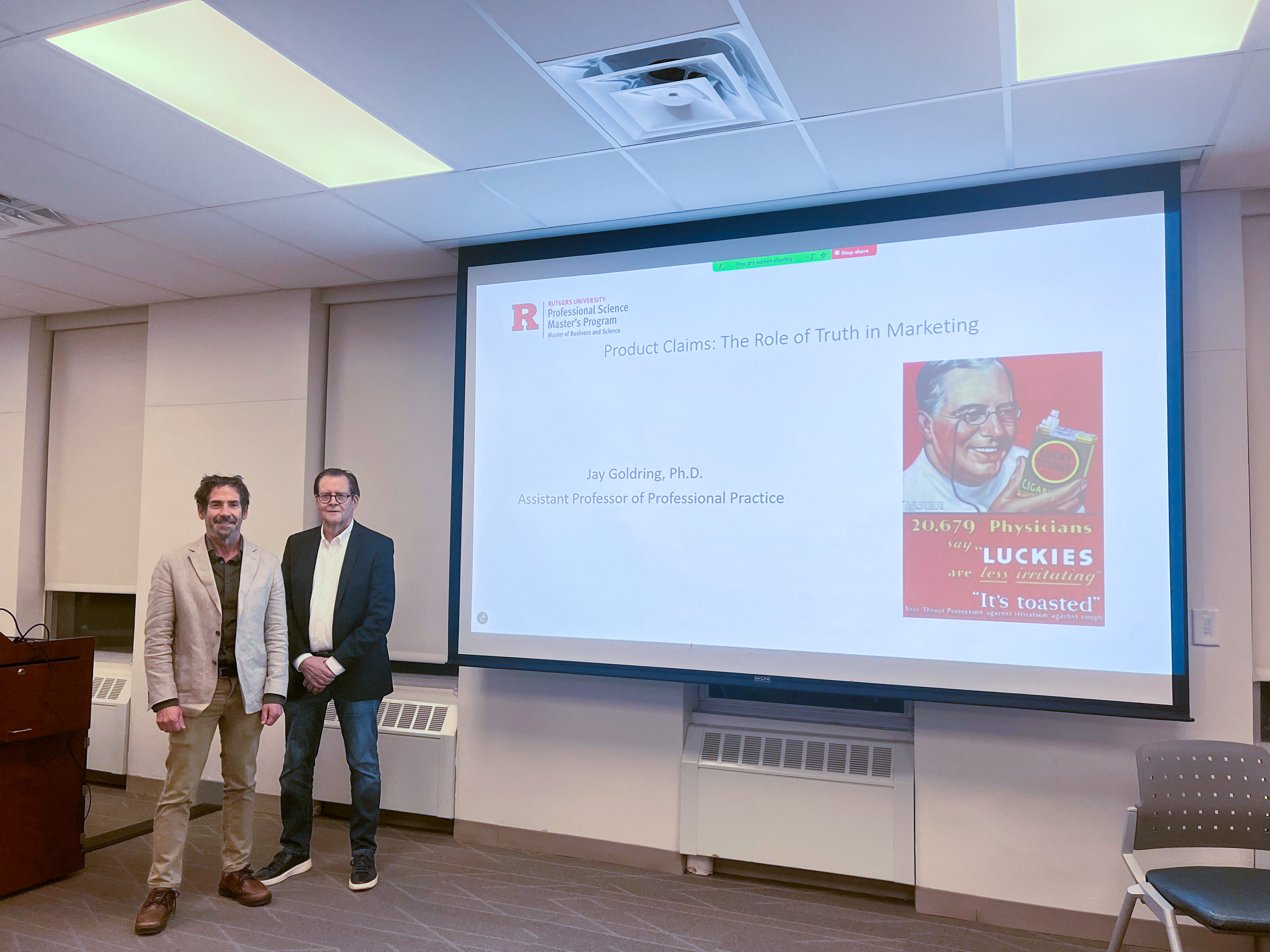 Two Professors standing ready to deliver a presentation 