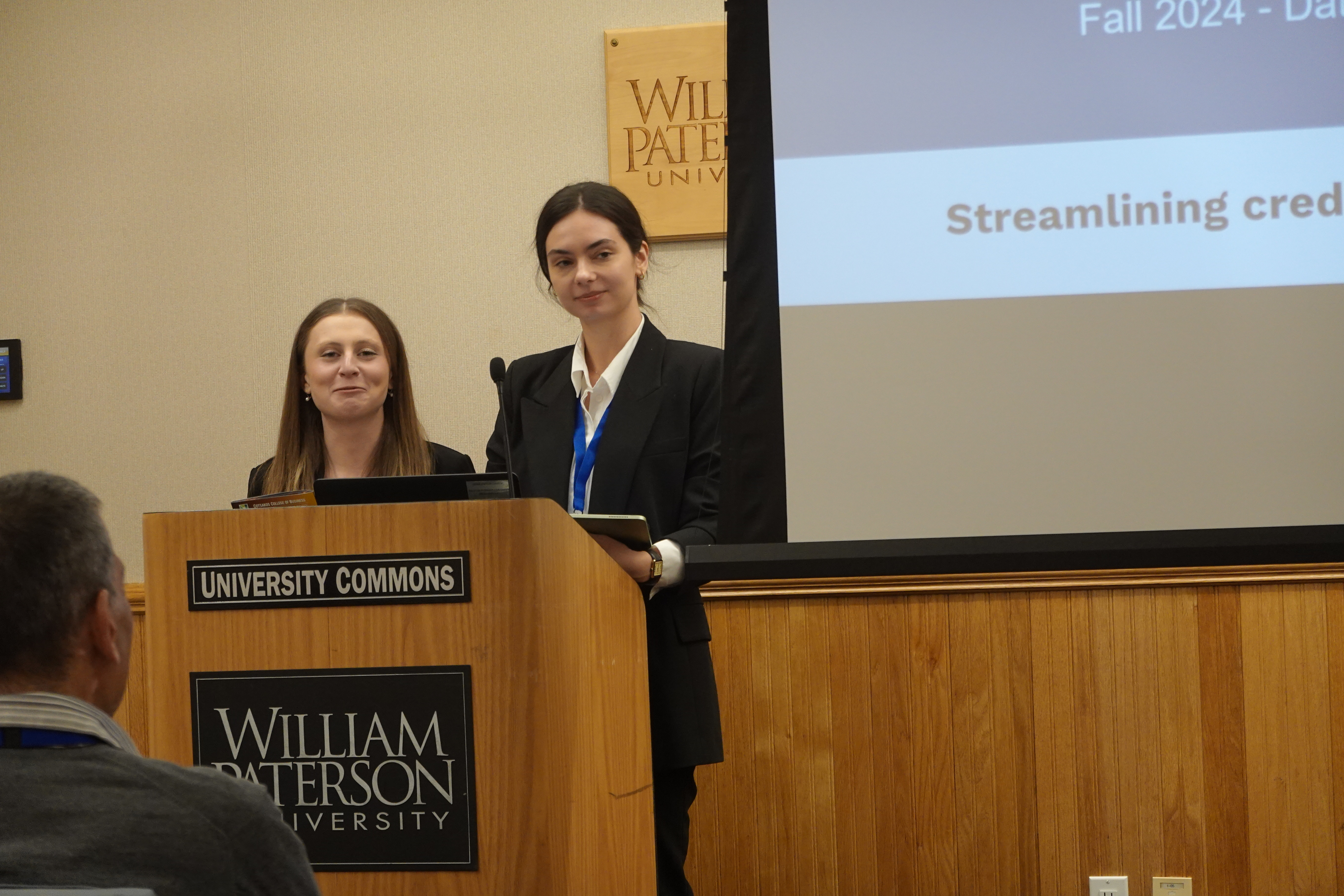 two people speaking at podium