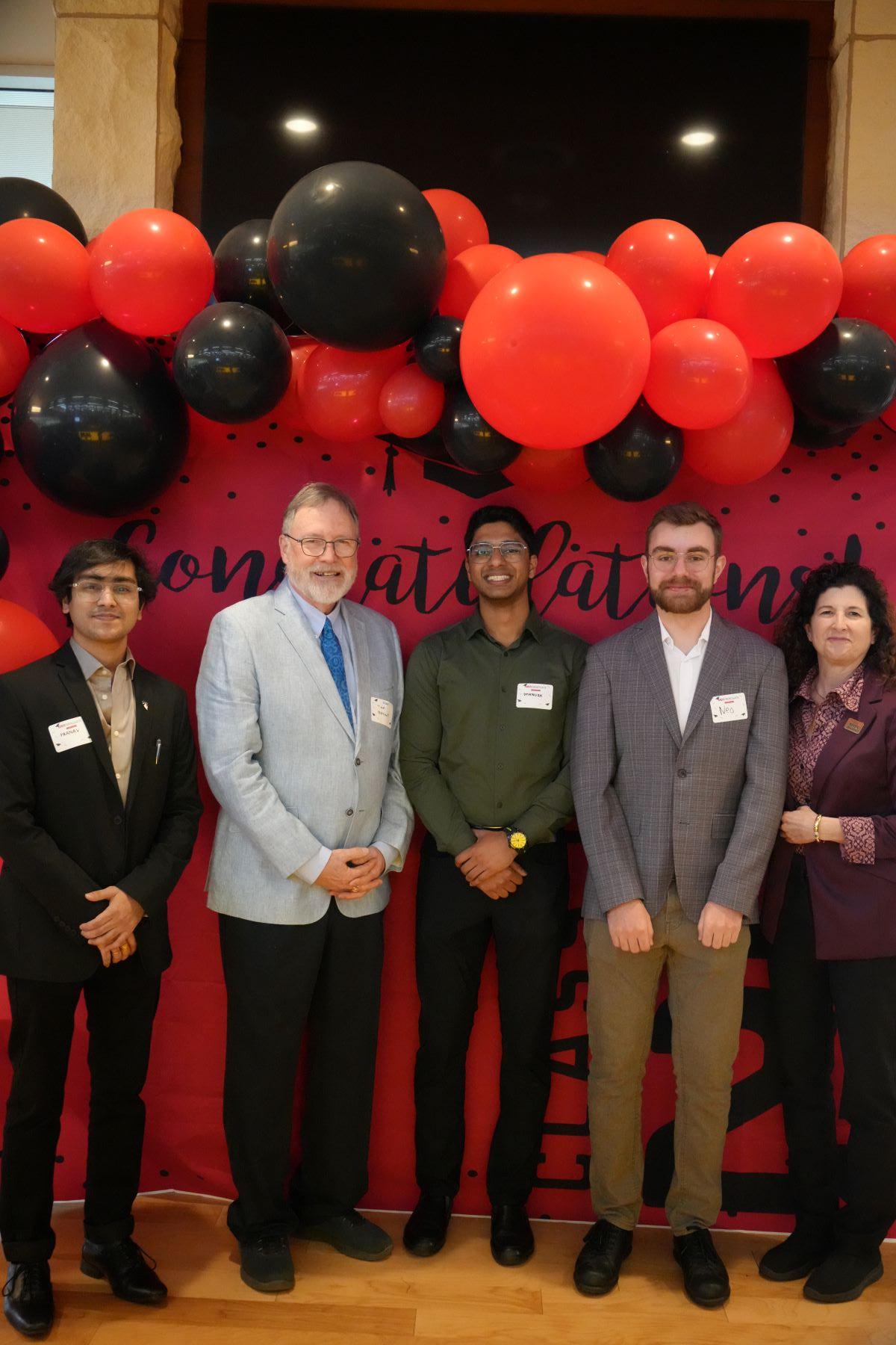 students and faculty standing in front of backdrop