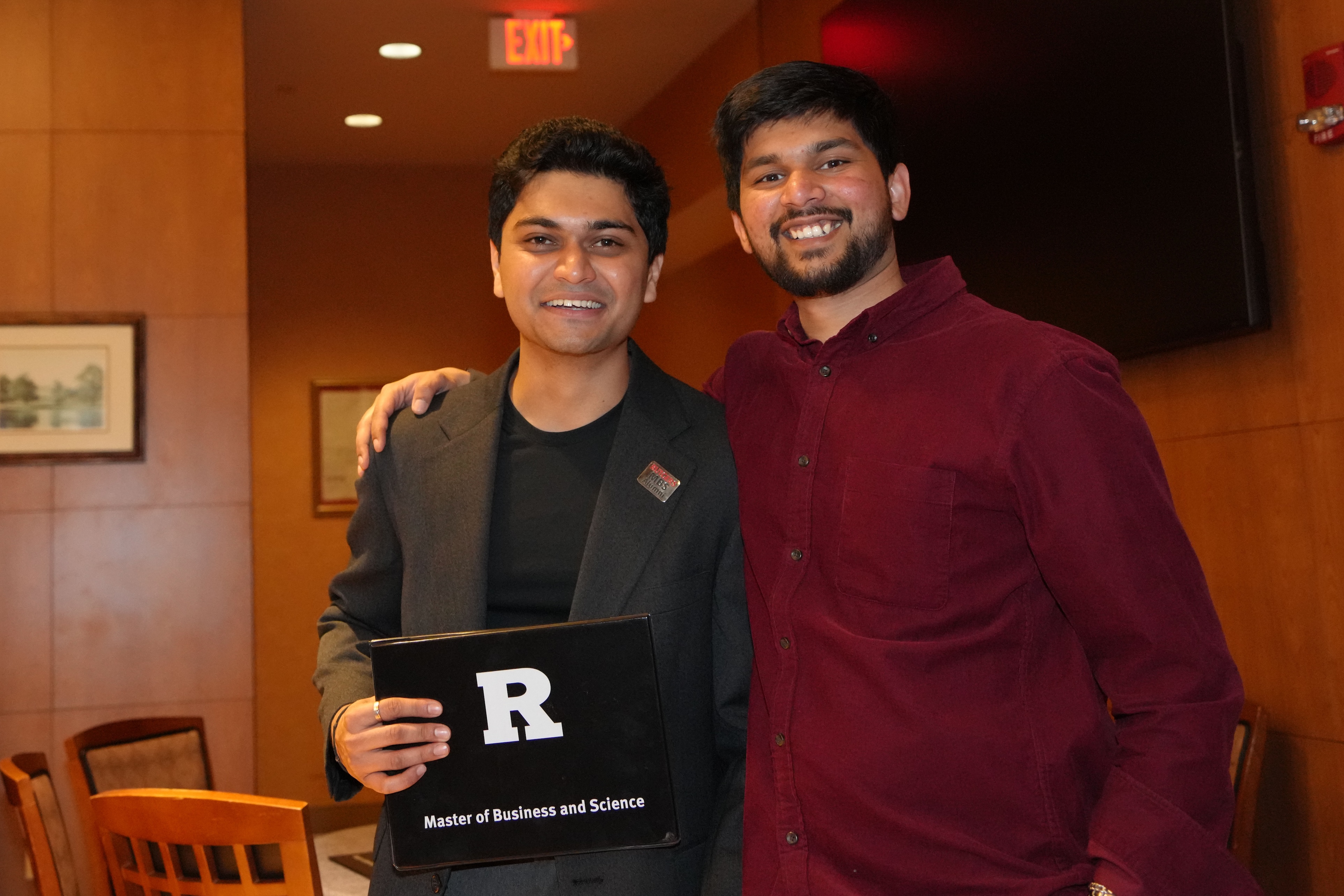 two graduates smiling