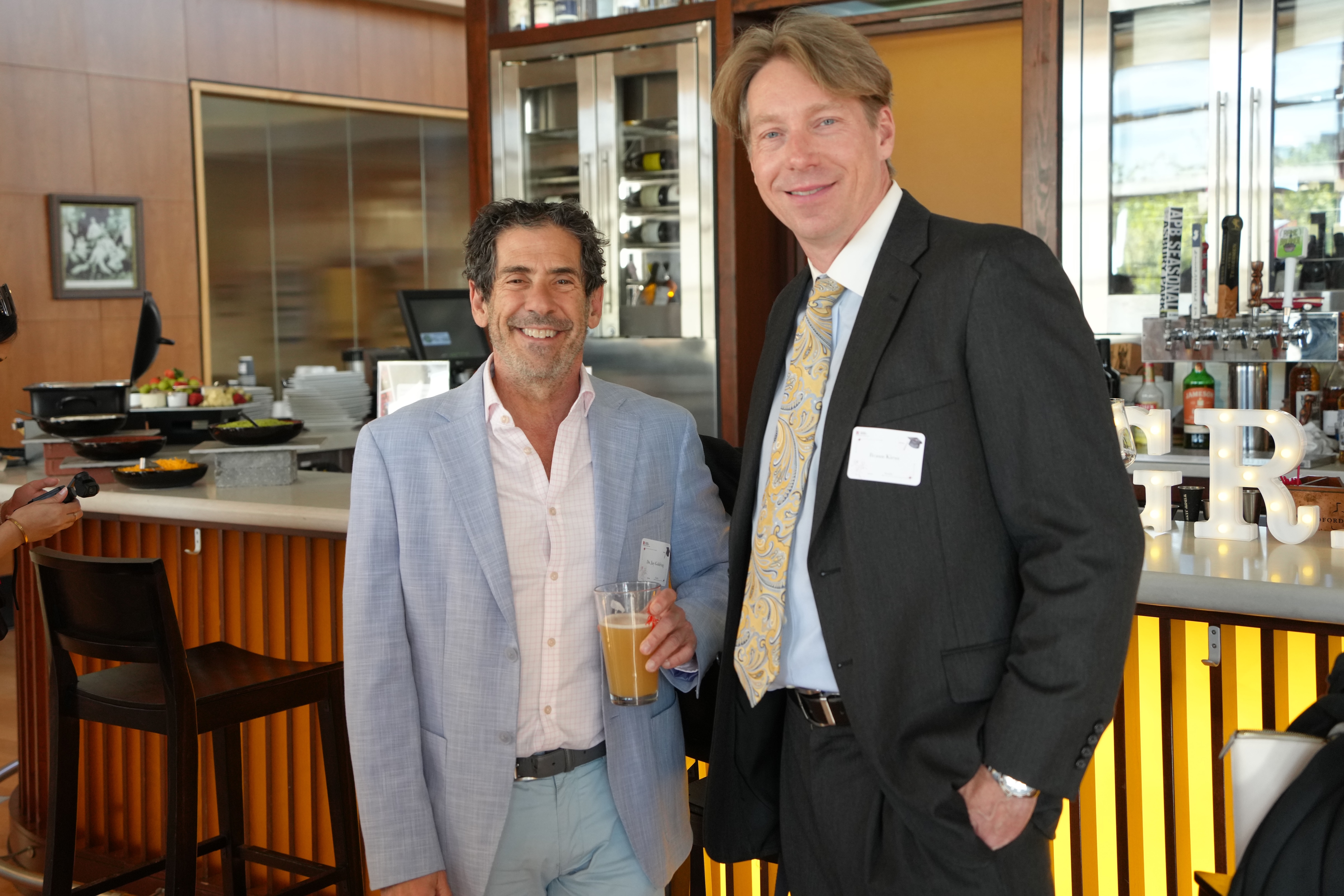 two men posing in front of a bar