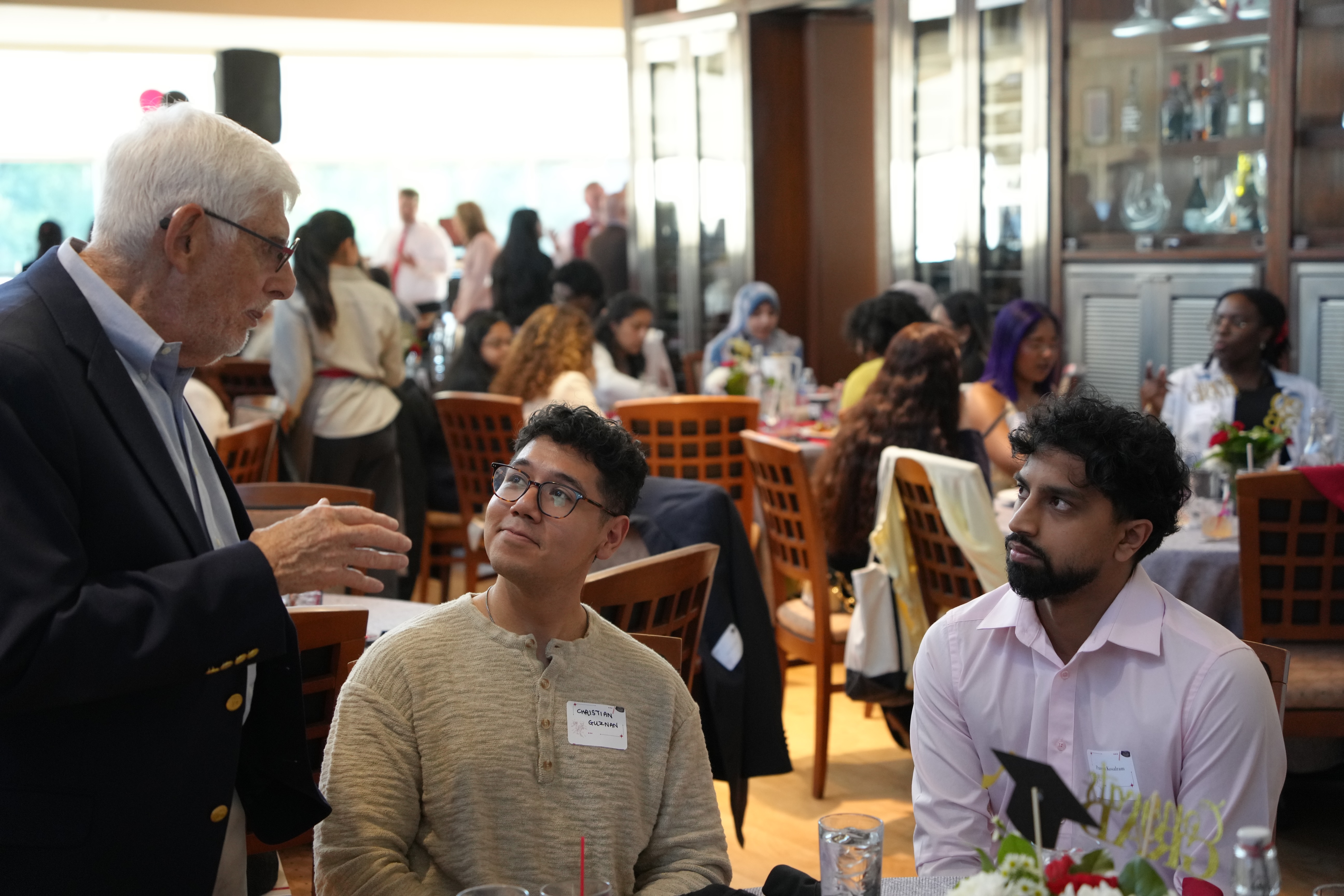 instructor speaking to two graduates