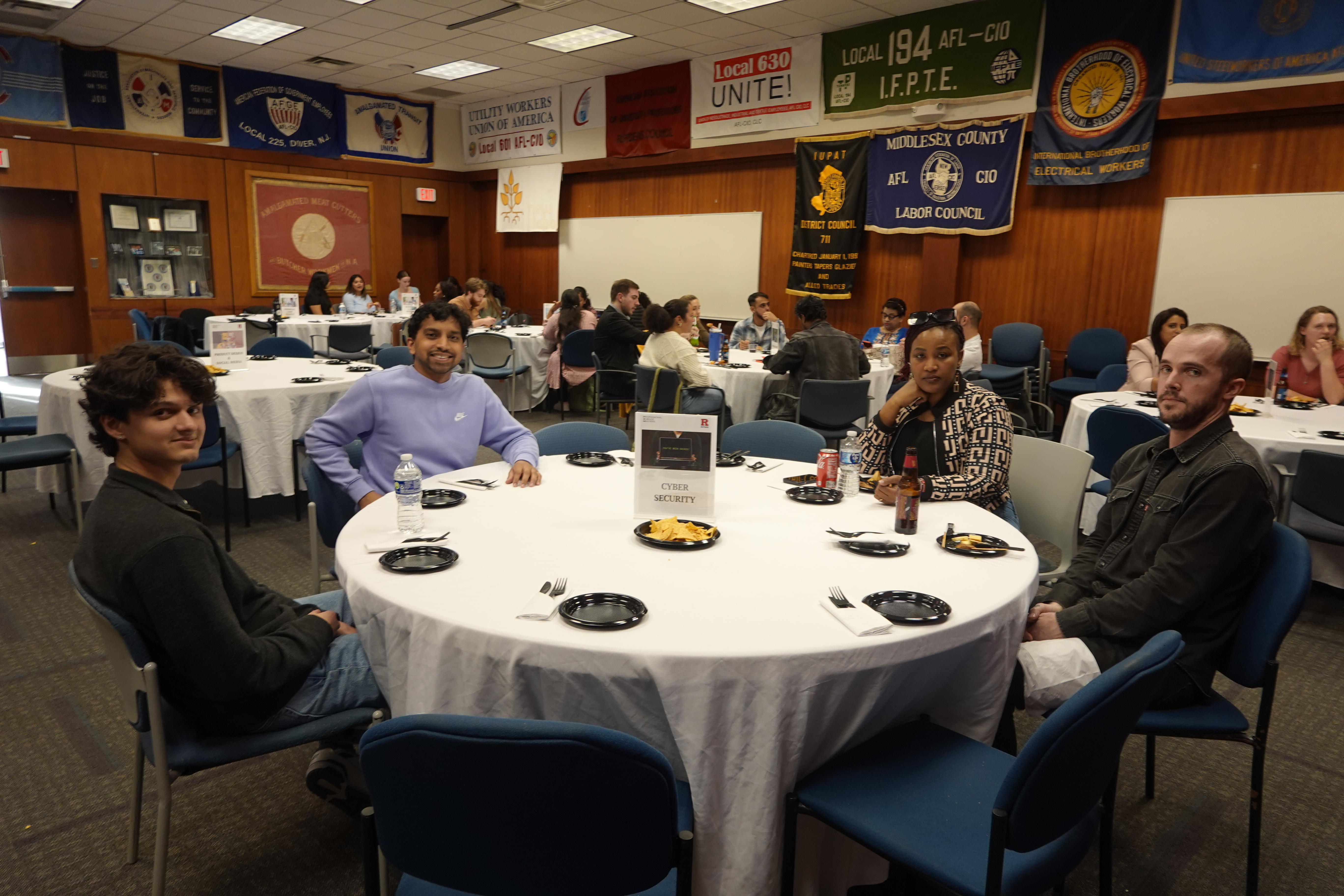 people sitting at table smiling at calera