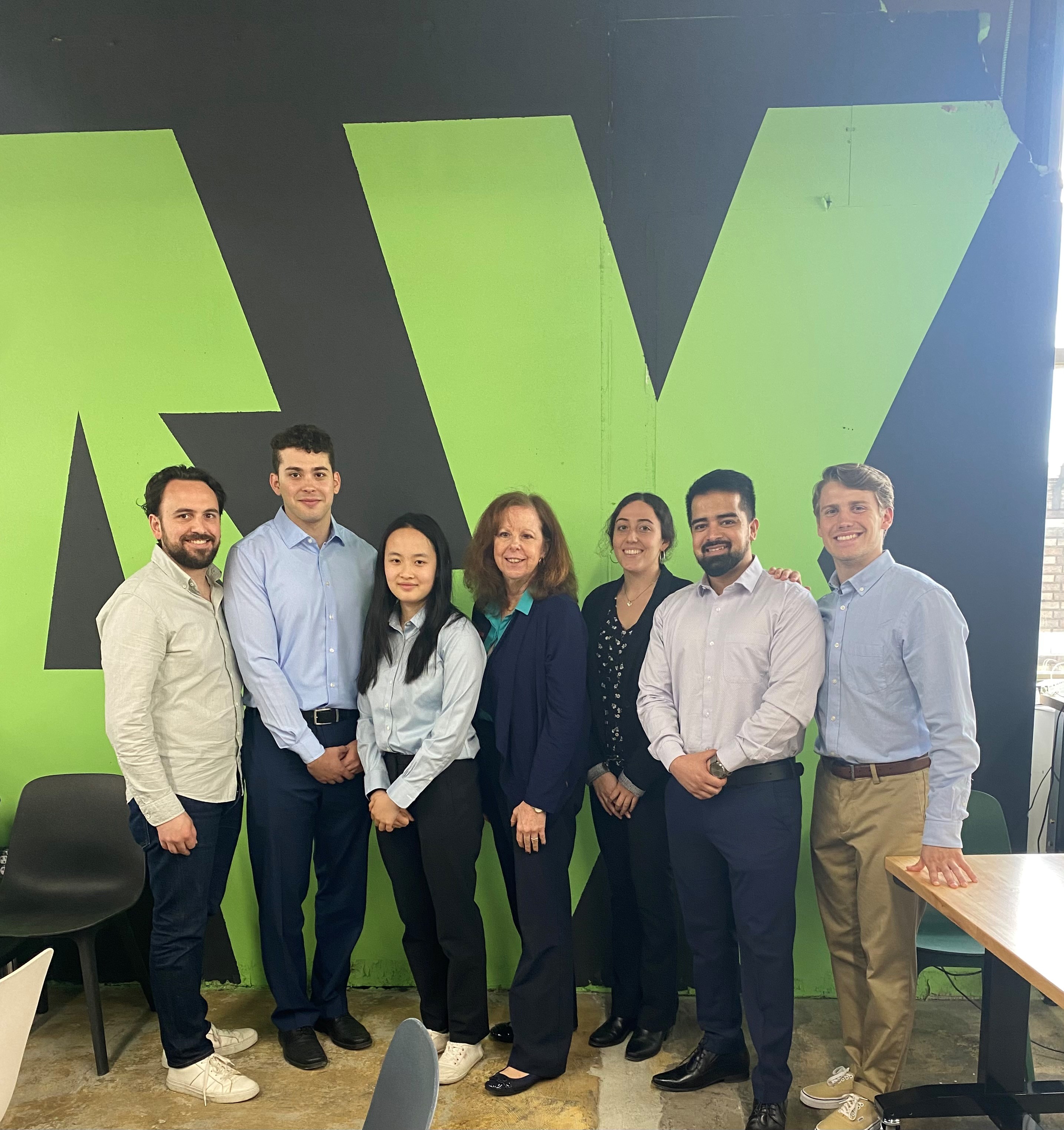 Group of people standing in front of logo