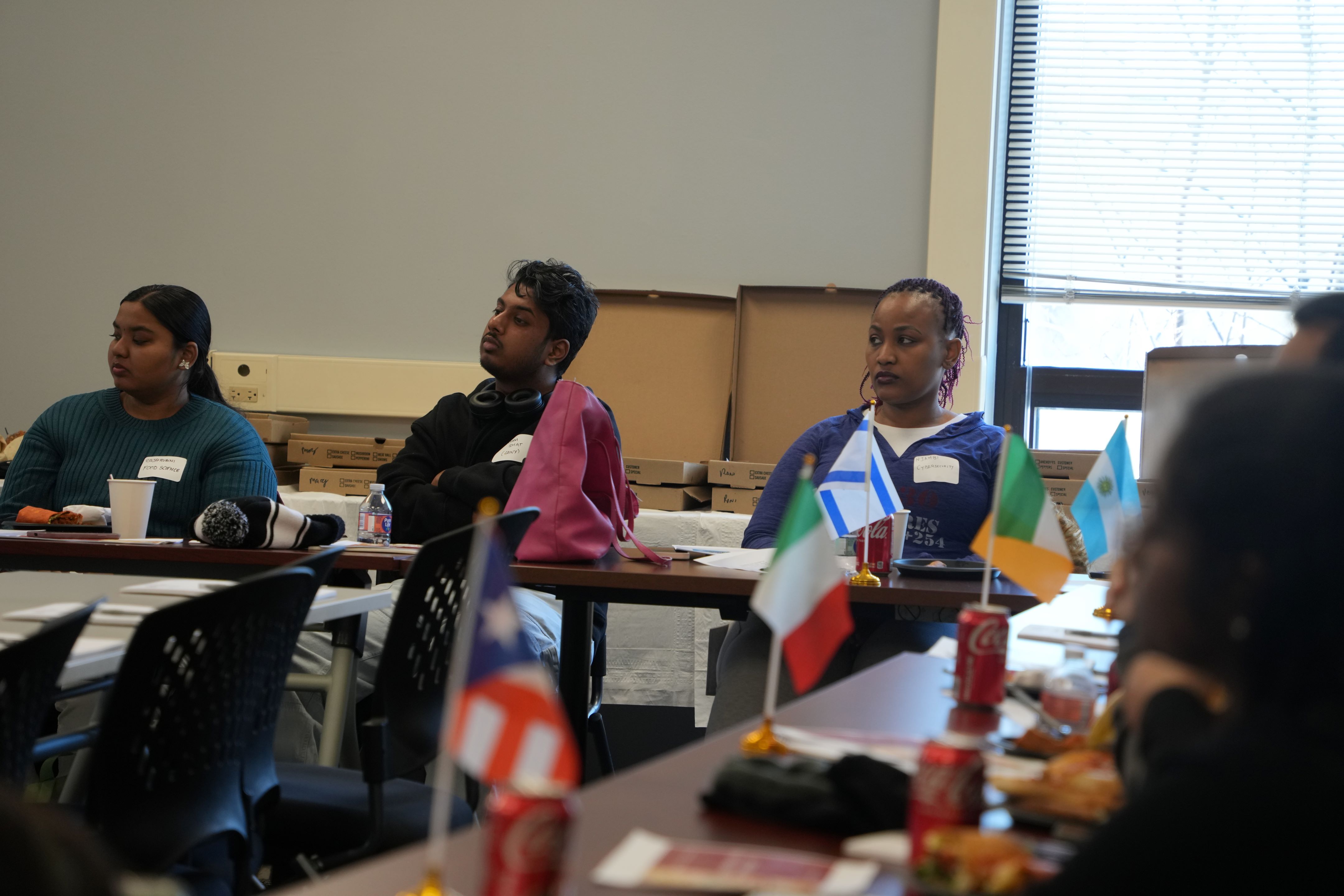 students sitting at table with small flags at table