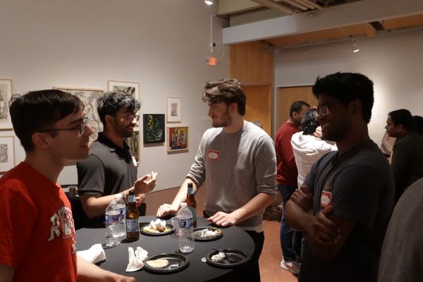 Four people having a discussion over food and drinks