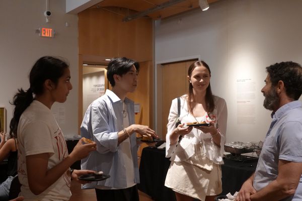 Three students talking to their professor
