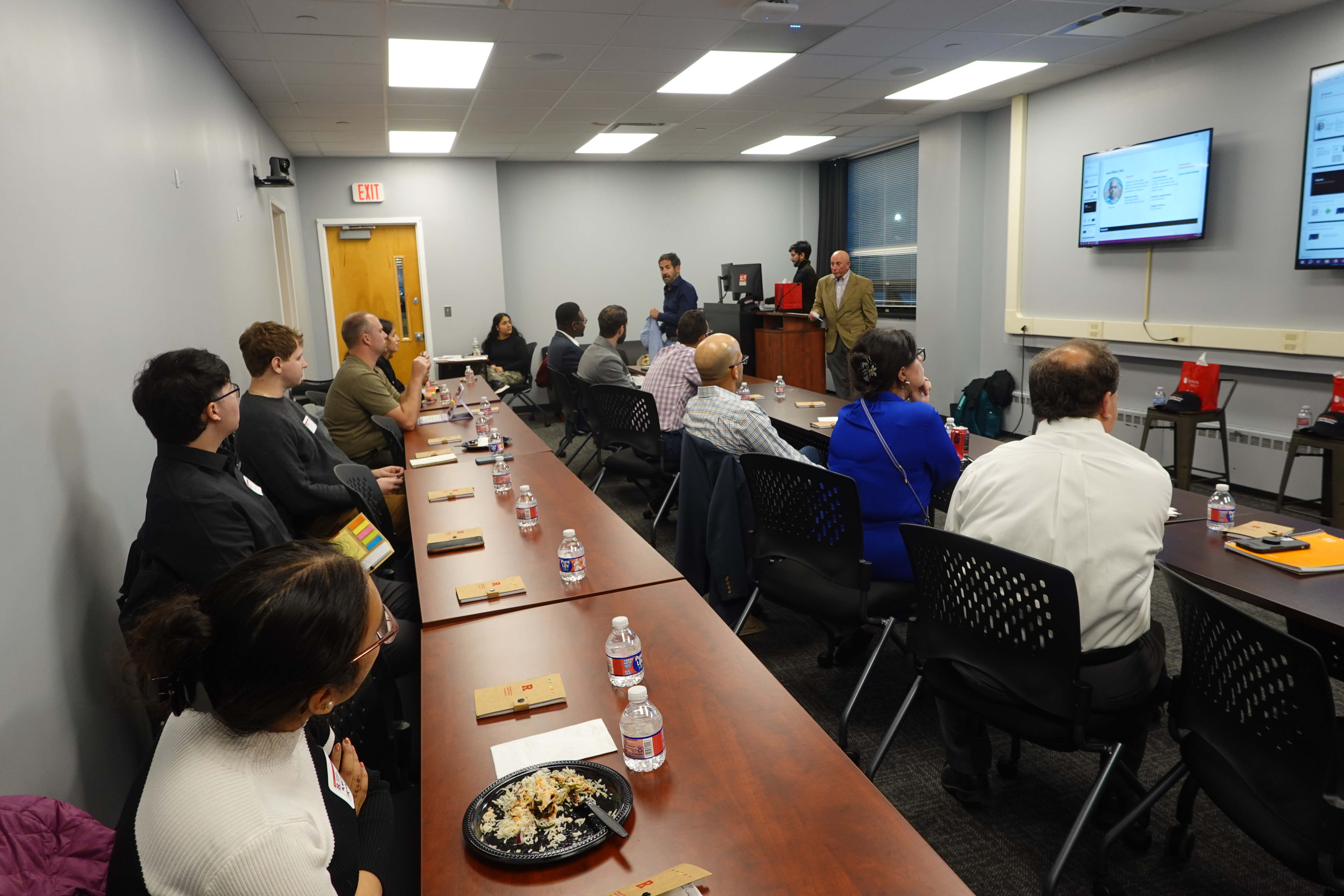 A group of people looking at the presentation in the classroom