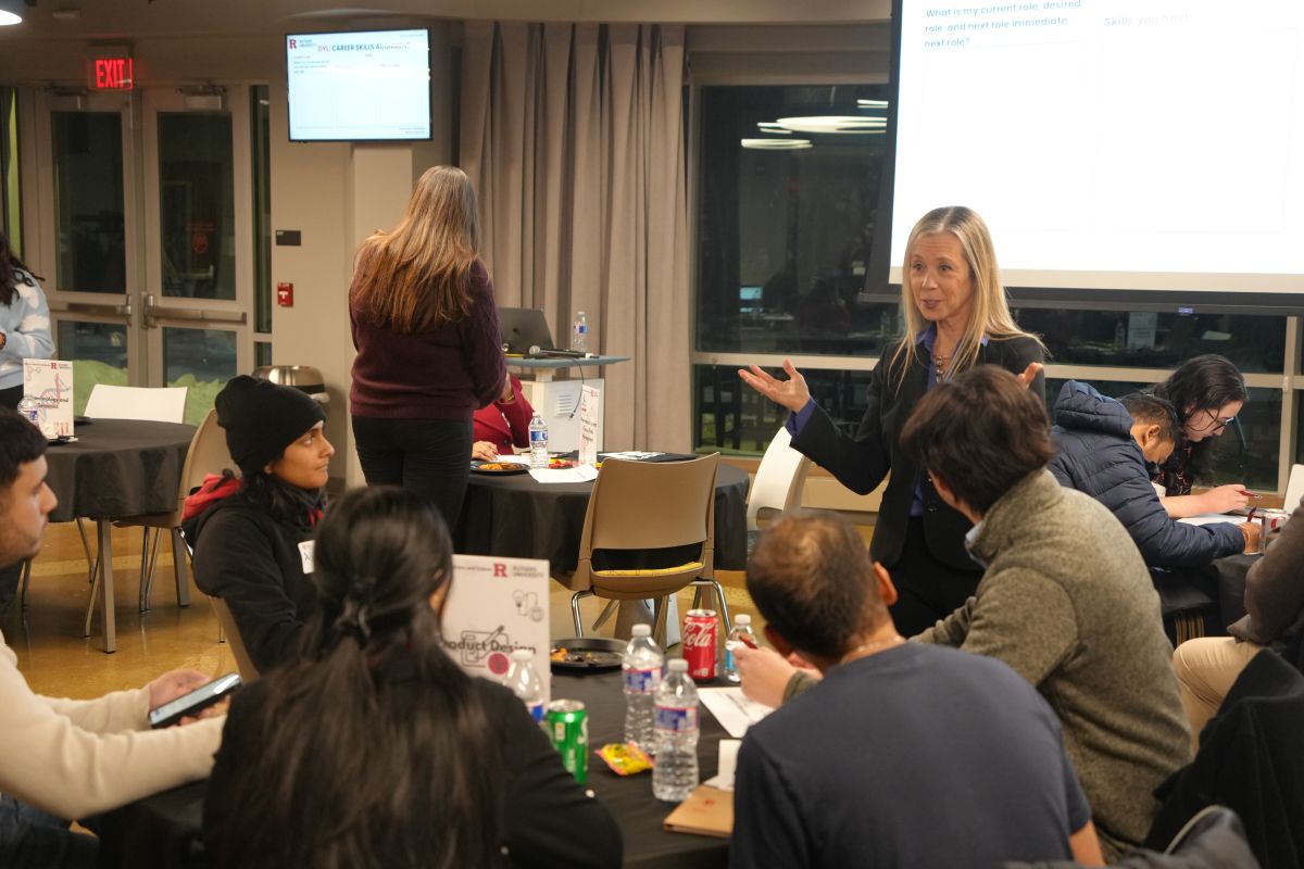 A lady talking to a group of students