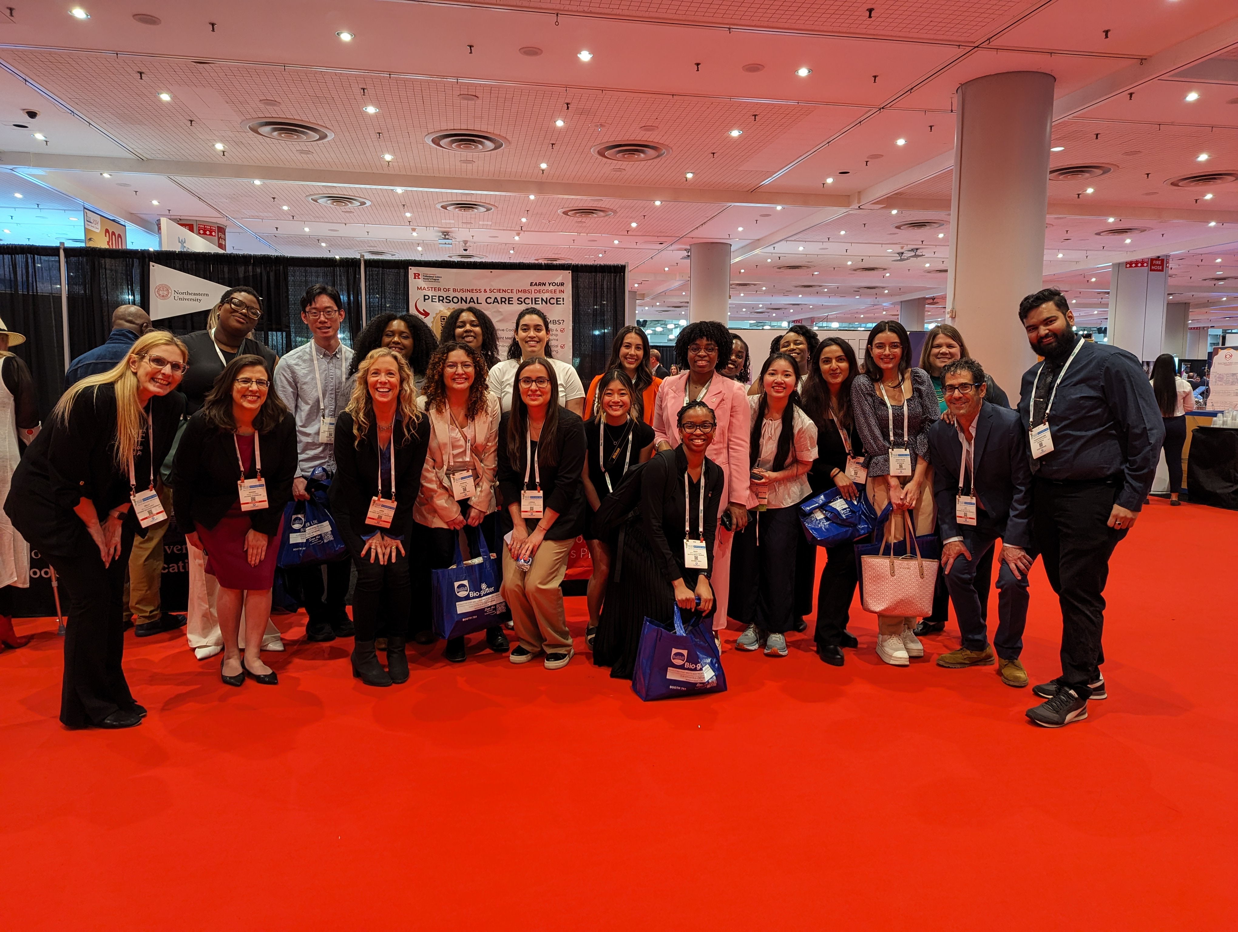 group photo of people standing on red carpet