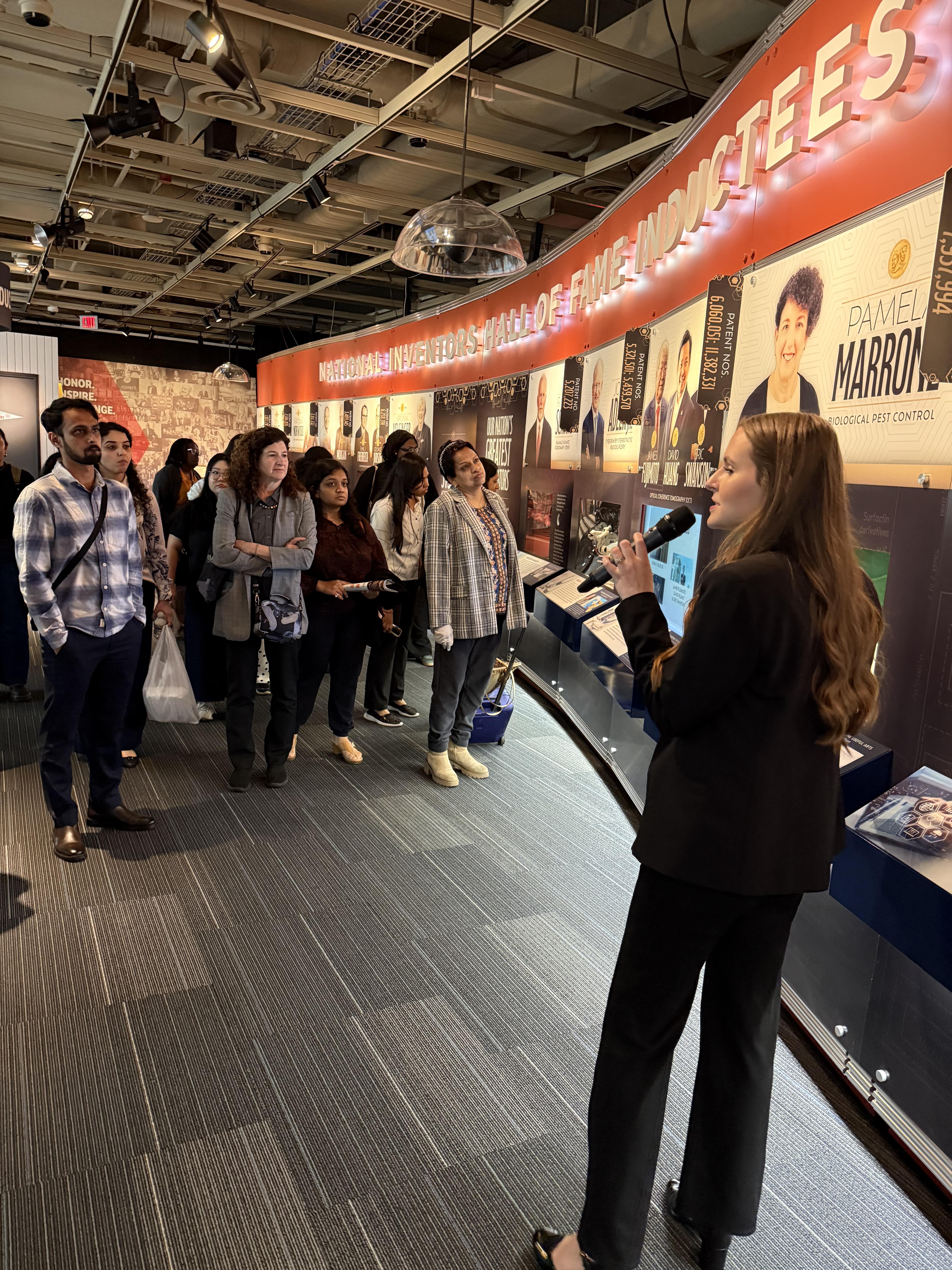 woman with microphone speaking at museum