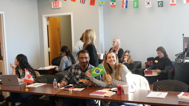 students smile and hold flag
