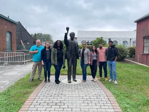 MBS students and coach posing with Thomas Edison statue